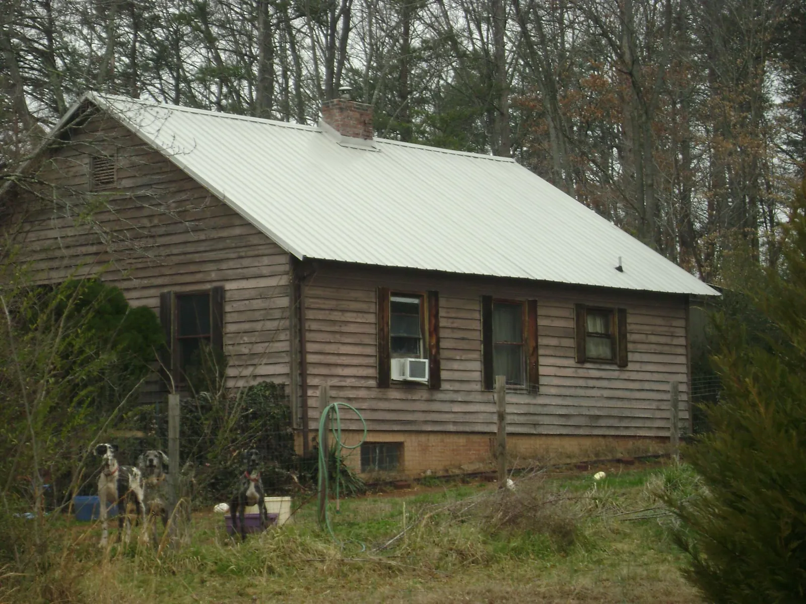 White metal roof on an old wood sided farmhouse, from a Metal Roof Installation job in Goshen